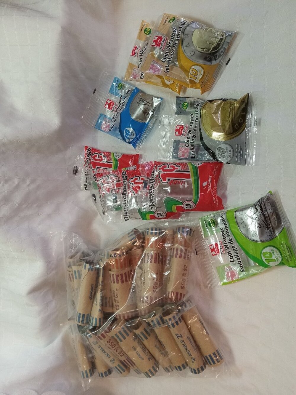 Several new packages of plastic coin rolls and numerous paper rolls